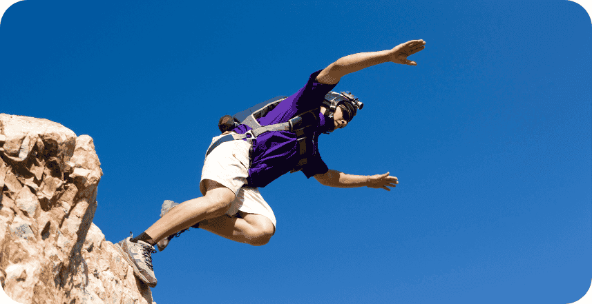 Solo BASE Jumper initiating a jump